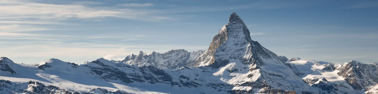 The Matterhorn rising above snow-covered Alpine peaks under a blue winter sky