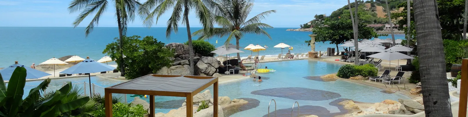 An infinity pool, palm trees and a shaded daybed above the sea at Chaweng Noi Beach, Koh Samui